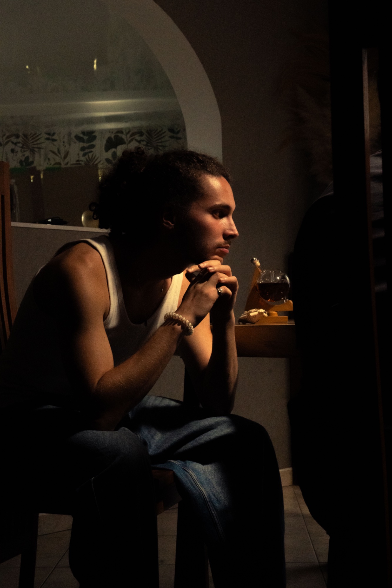 APORIE — still cinéma, personnage en débardeur, clair-obscur intérieur cuisine