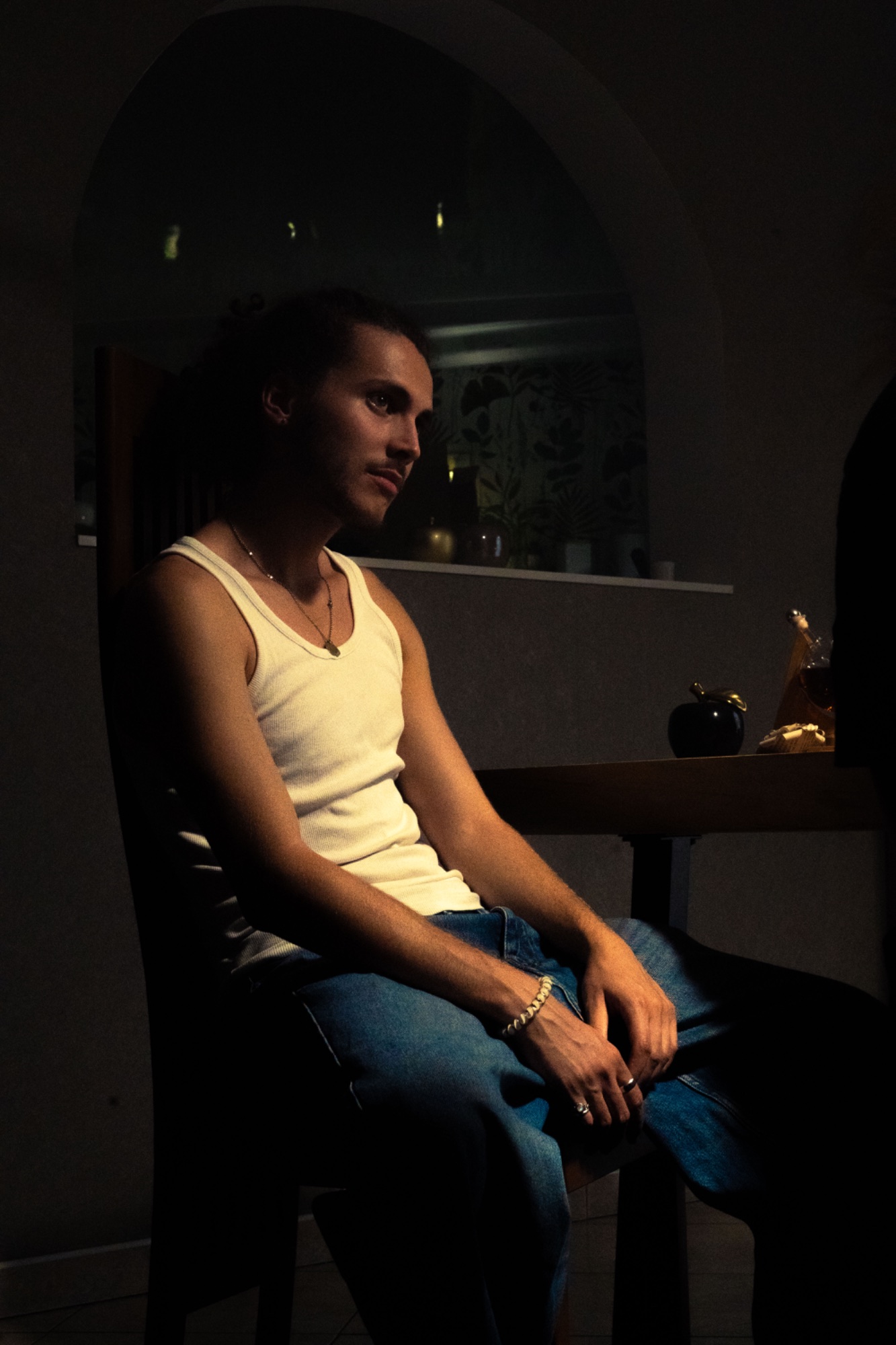 APORIE — still cinéma, portrait en débardeur de profil, arche en arrière-plan