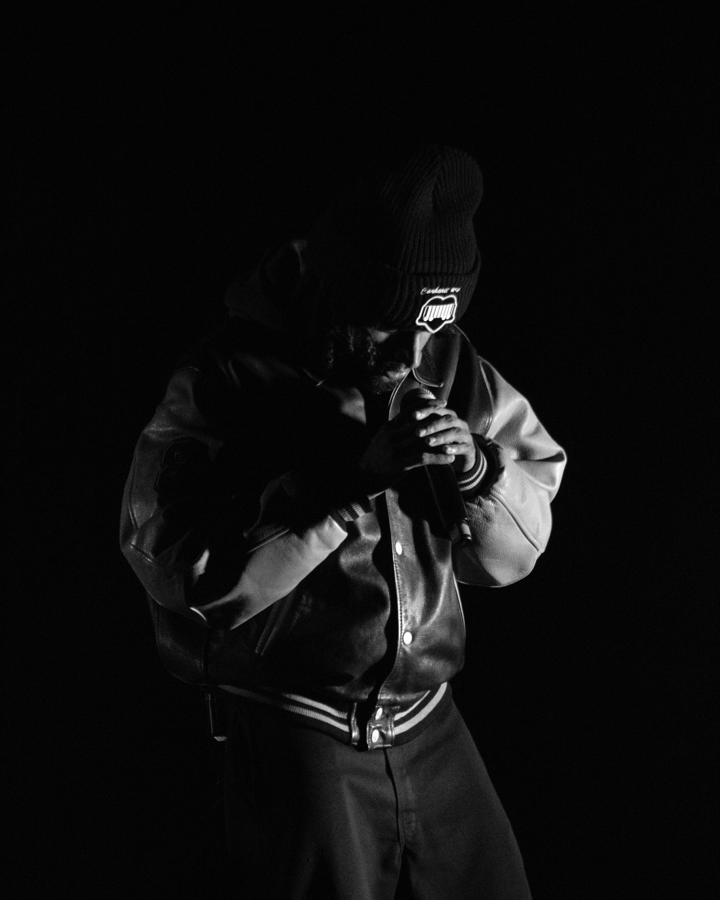 Portrait sur fond noir, veste varsity